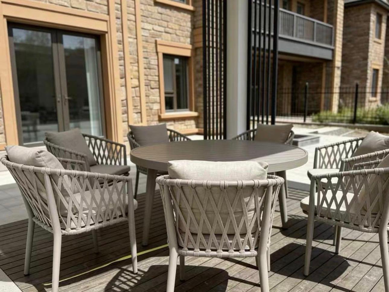 The Aira The Aira – round outdoor dining table with taupe diamond-lattice rope chairs